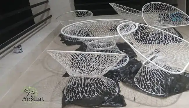 ست ۵ نفره میز و صندلی ویلایی دست دوم تهران با سطح زنگ زده و فردی در حال رنگ کردن زنگ زدگی ها