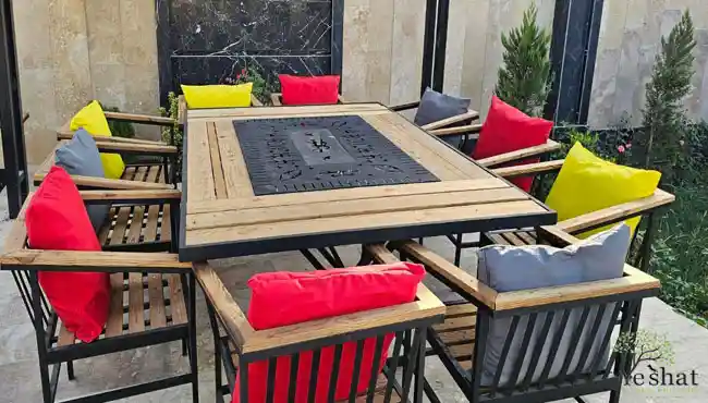 ست ده نفره میز صندلی چوبی فلزی با تشکهای رنگارنگ در حیاط خانه ای در قم