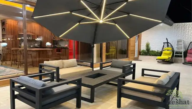 ست ۶نفره میز و صندلی باغی در قم با تشک طوسی و یک سایبان طوسی که در حیاط واقع شده