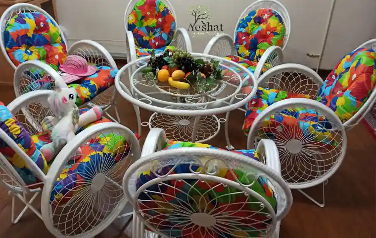 میز و صندلی باغی فلزی با طراحی مینیمال در میان فضای سبز دل‌انگیز – محصول گالری نشاط