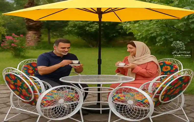 زن و شوهری در حال نوشیدن چای روی میز و صندلی باغی گالری نشاط در باغ خانوادگیشان